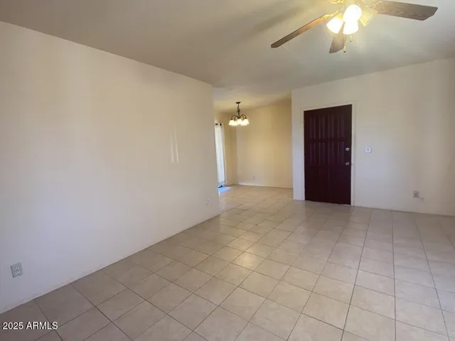 en empty room with windows and ceiling fan