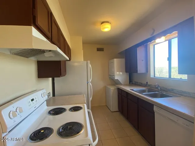 a kitchen with a sink a stove and a refrigerator