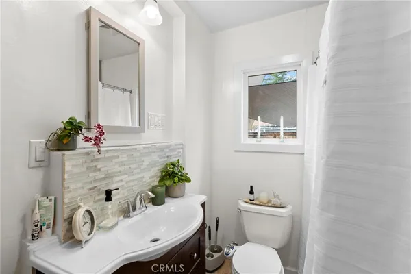 a bathroom with a sink mirror and toilet