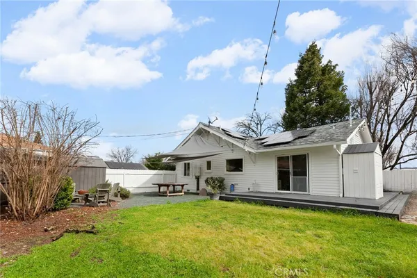 a front view of a house with a garden and a tree