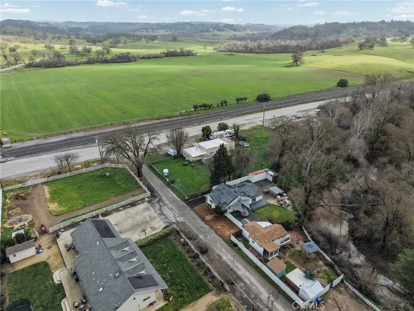 an aerial view of a residential houses with outdoor space and mountain view