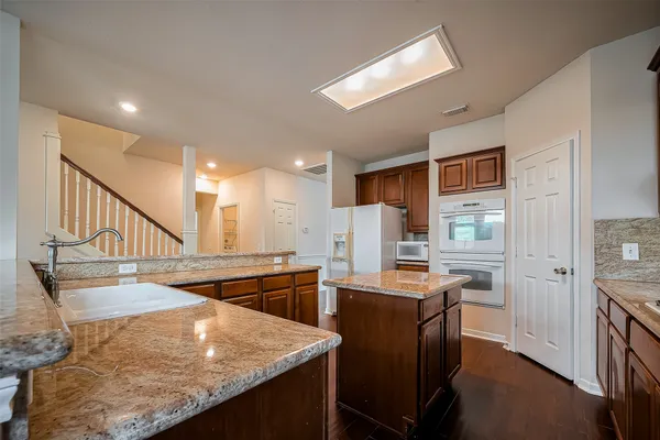 a kitchen with stainless steel appliances kitchen island granite countertop a sink and cabinets