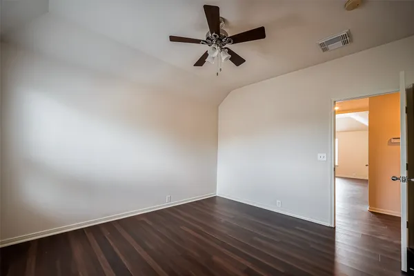 a view of a room with wooden floor and a ceiling fan
