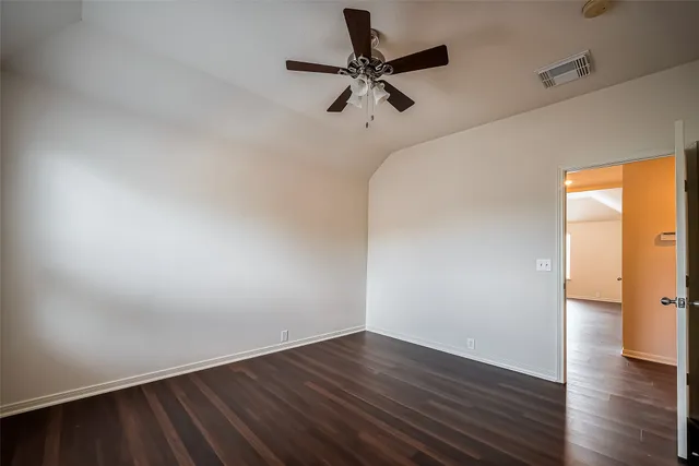 a view of a room with wooden floor and a ceiling fan