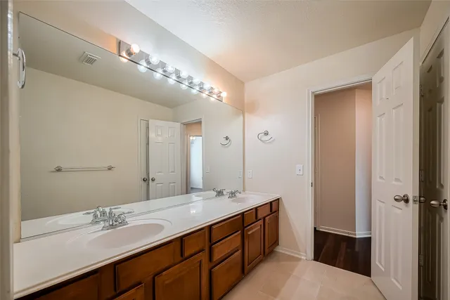 a bathroom with a double vanity sink and a mirror