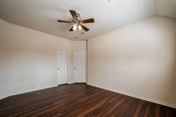 a view of a room with wooden floor and fan