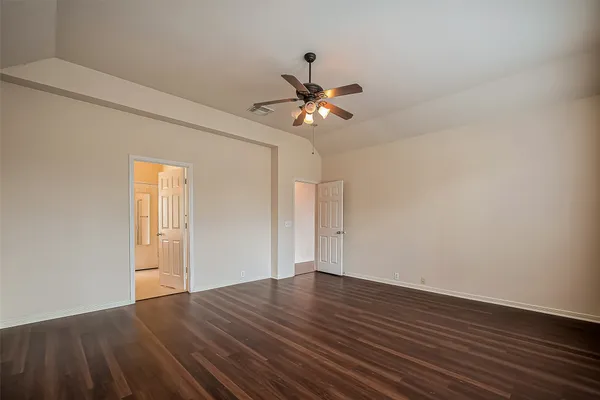 a view of a room with wooden floor and a ceiling fan