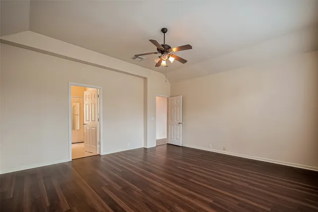 a view of a room with wooden floor and a ceiling fan