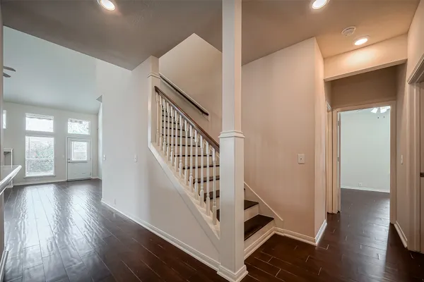 a view of a hallway with wooden floor and staircase