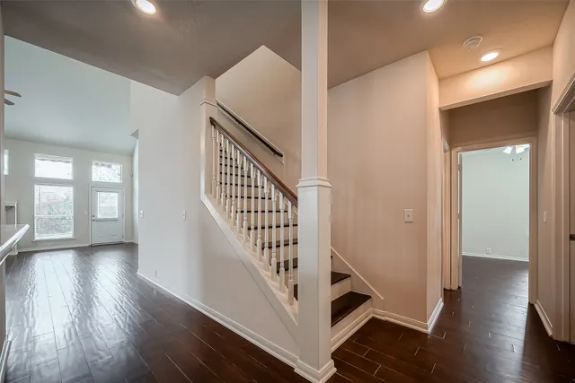 a view of a hallway with wooden floor and staircase