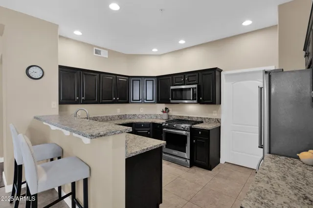 a kitchen with stainless steel appliances granite countertop a stove and a refrigerator