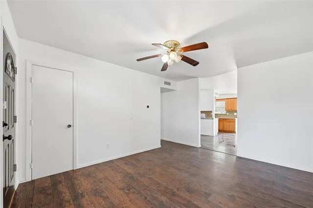 a view of a big room with wooden floor and a ceiling fan