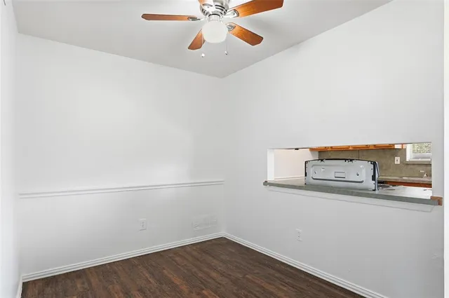 an empty room with a ceiling fan and wooden floor