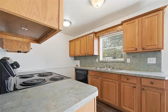 a kitchen with a stove a sink and a cabinets