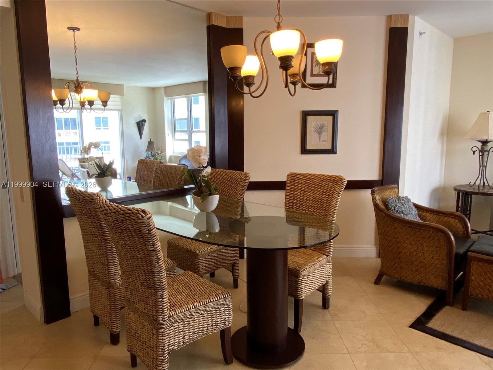 701 Brickell Key Boulevard, Unit 2104 Miami, FL 33131 - Photo 3 of 13 a living room with furniture a chandelier and a dining table