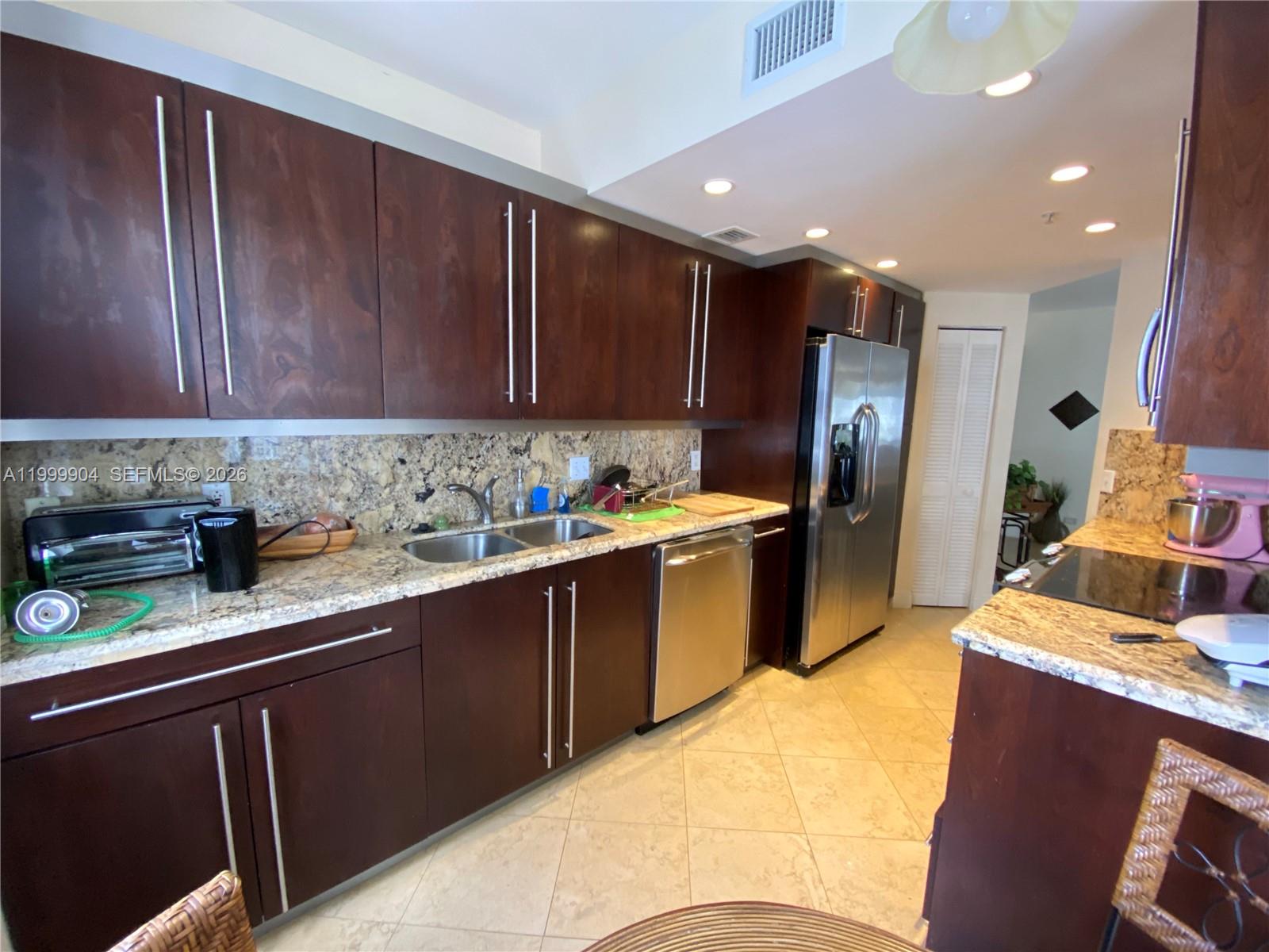 701 Brickell Key Boulevard, Unit 2104 Miami, FL 33131 - Photo 4 of 13 a kitchen with refrigerator and cabinets