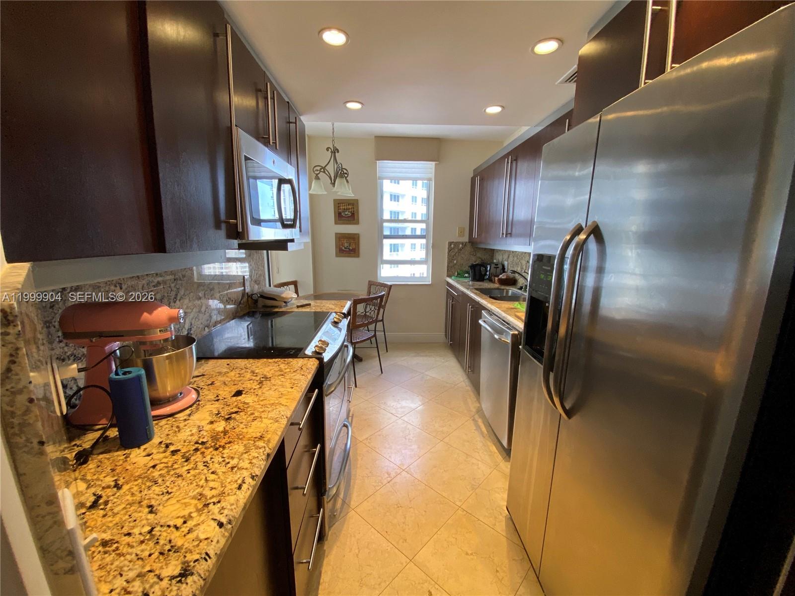 701 Brickell Key Boulevard, Unit 2104 Miami, FL 33131 - Photo 5 of 13 a kitchen with stainless steel appliances granite countertop a sink a stove and a refrigerator