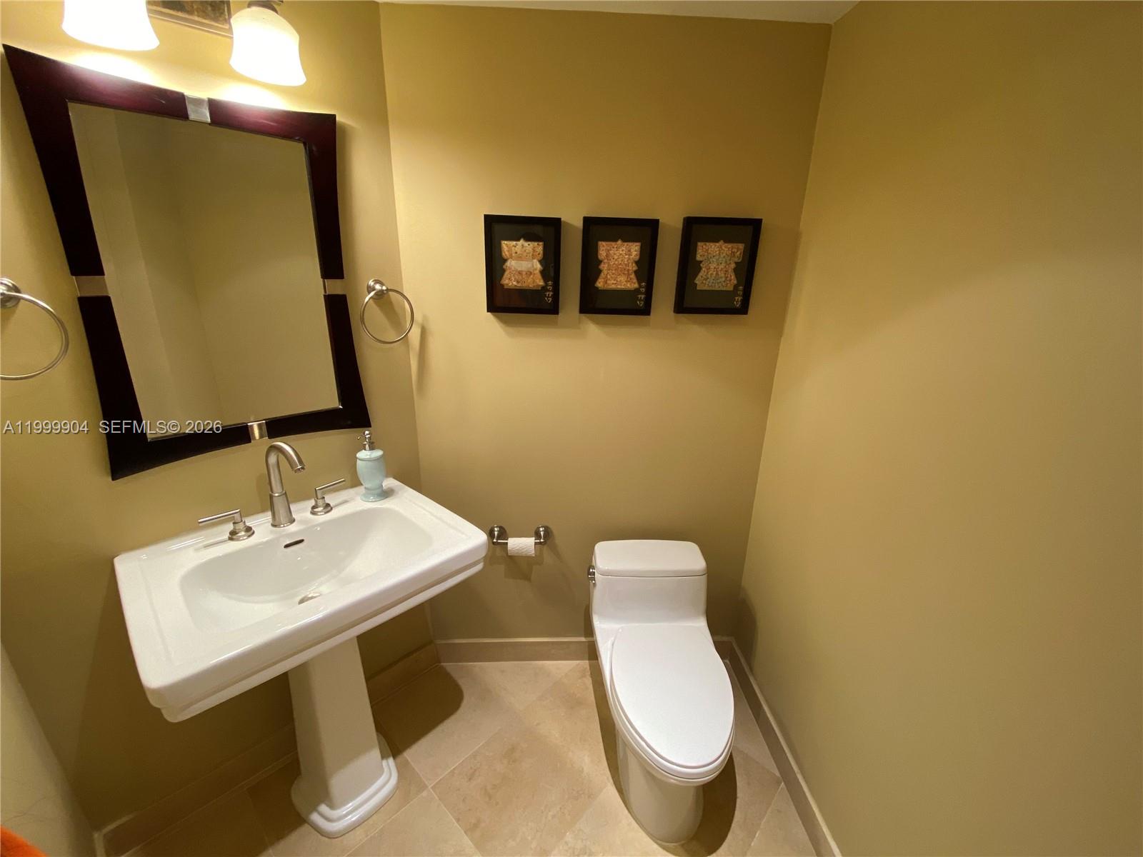 701 Brickell Key Boulevard, Unit 2104 Miami, FL 33131 - Photo 6 of 13 a bathroom with a toilet sink and mirror