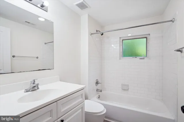 a bathroom with a shower sink vanity and mirror