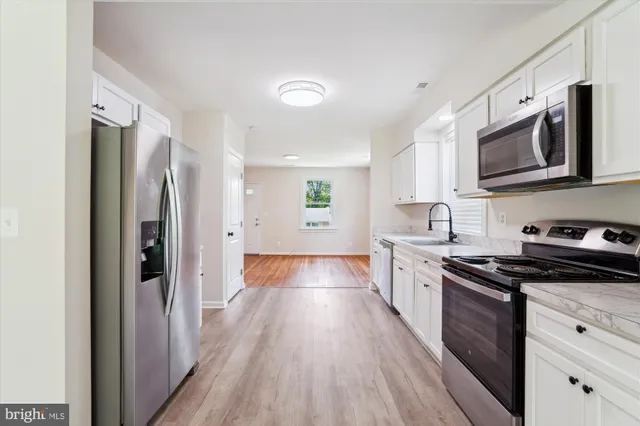 a kitchen with a refrigerator a sink and wooden cabinets