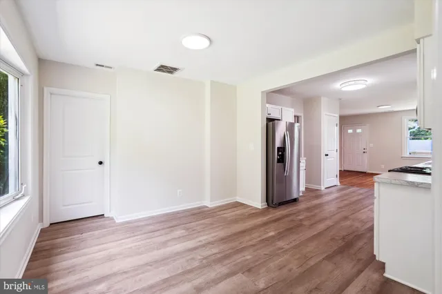 a kitchen with stainless steel appliances granite countertop a stove top oven a sink dishwasher and a microwave oven with wooden floor