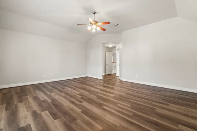 a view of a livingroom with wooden floor and a ceiling fan