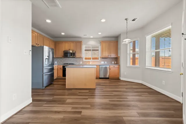 a kitchen with a refrigerator and a stove top oven