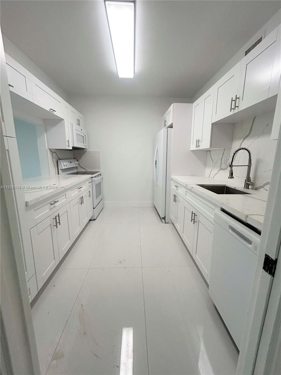 141 Crandon Boulevard, Unit 342 Key Biscayne, FL 33149 - Photo 11 of 25 a kitchen with granite countertop a sink stove and cabinets