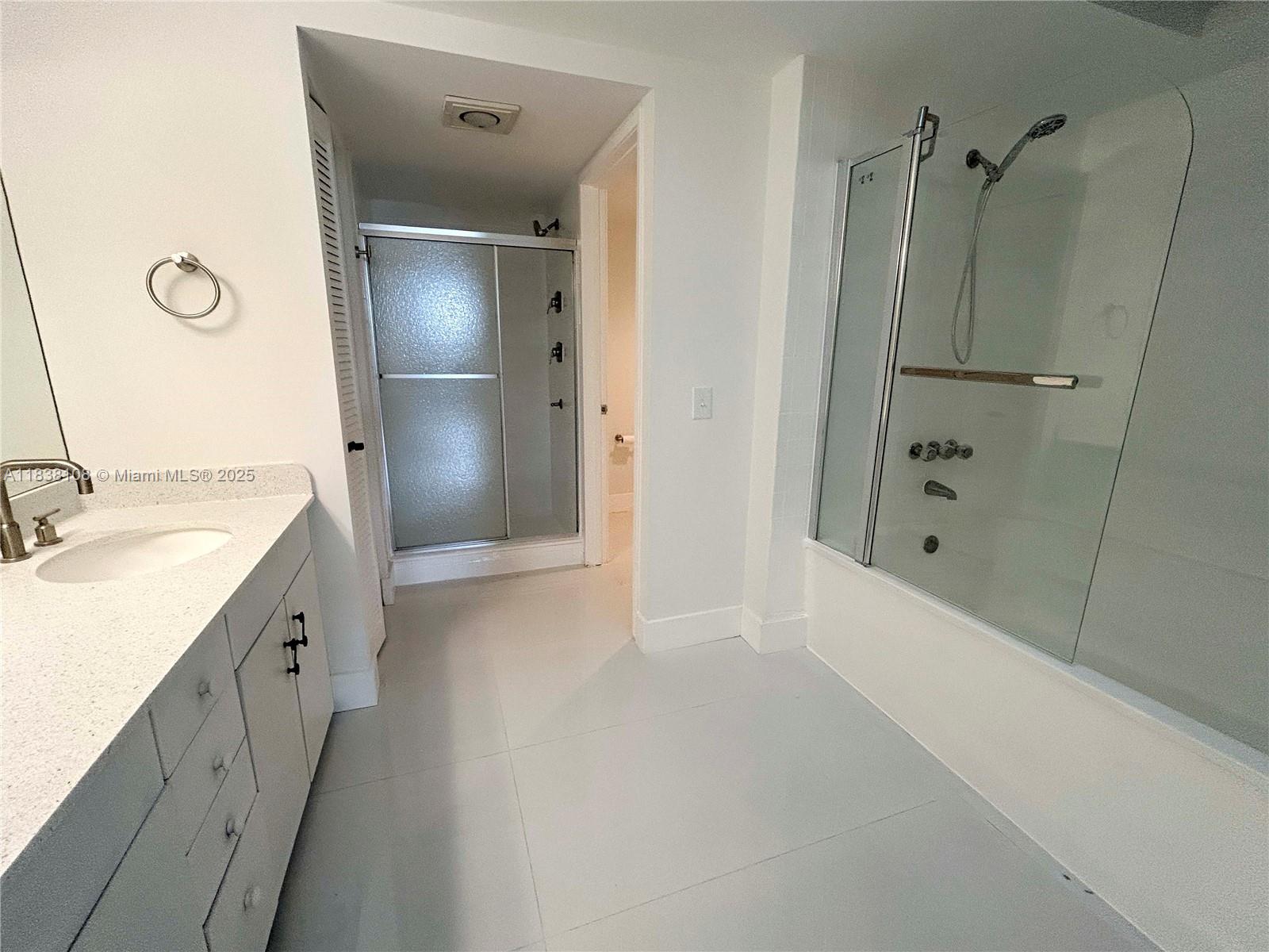 141 Crandon Boulevard, Unit 342 Key Biscayne, FL 33149 - Photo 17 of 25 a bathroom with a double vanity sink a mirror and a shower