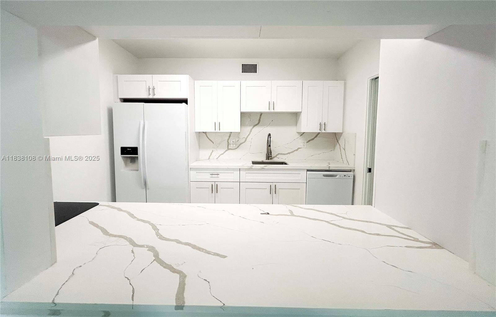 141 Crandon Boulevard, Unit 342 Key Biscayne, FL 33149 - Photo 9 of 25 a kitchen with stainless steel appliances kitchen island sink refrigerator and stove