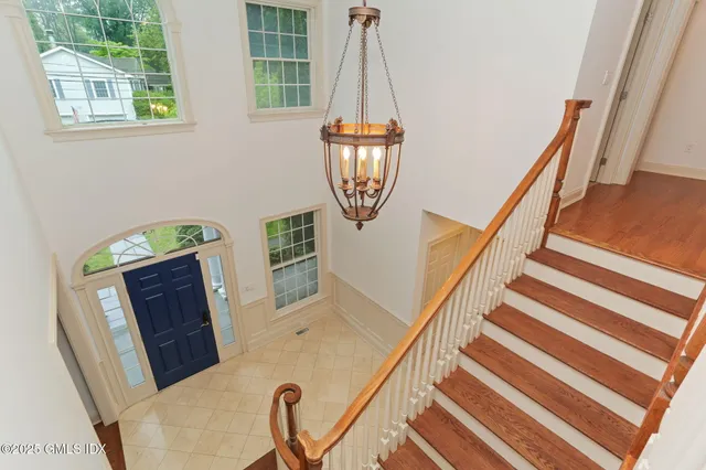 a view of a hallway with wooden floor and stairs