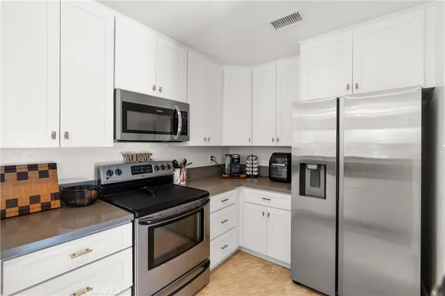 a kitchen with cabinets stainless steel appliances and a counter space
