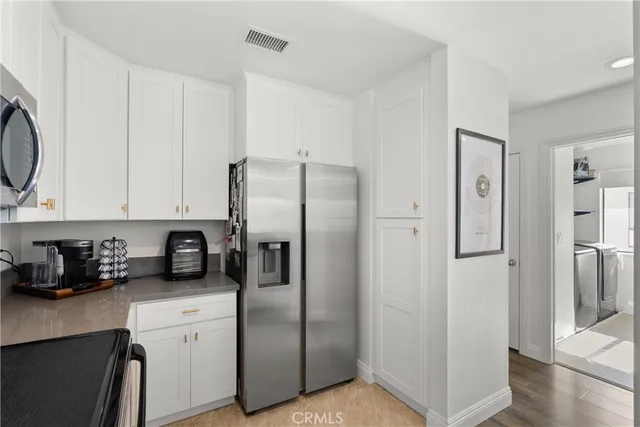 a kitchen with stainless steel appliances granite countertop a refrigerator and a stove top oven