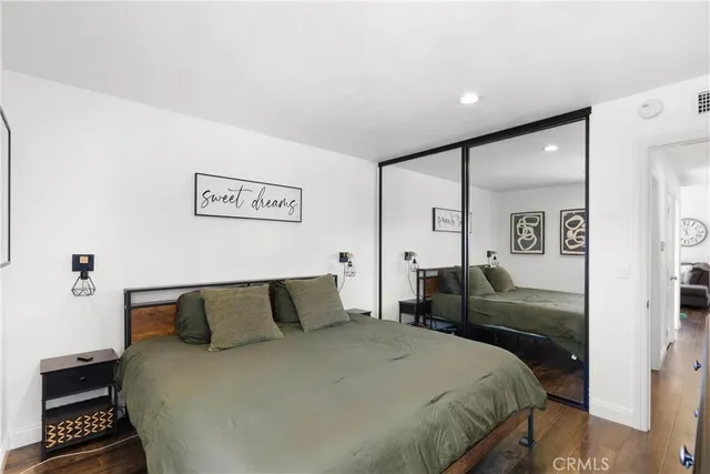 a bedroom with a bed and a lamp on dresser