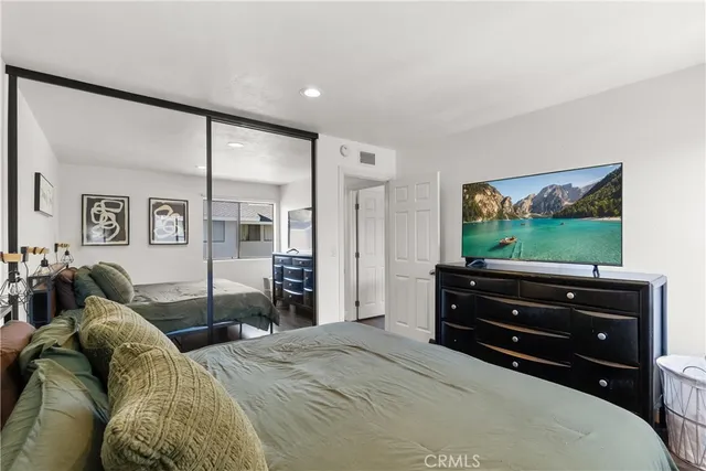 a bedroom with a bed and a flat screen tv