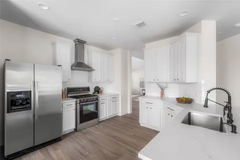 a kitchen with white cabinets stainless steel appliances and sink