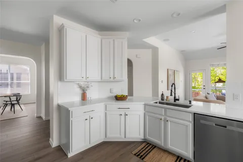 a kitchen with white cabinets and sink