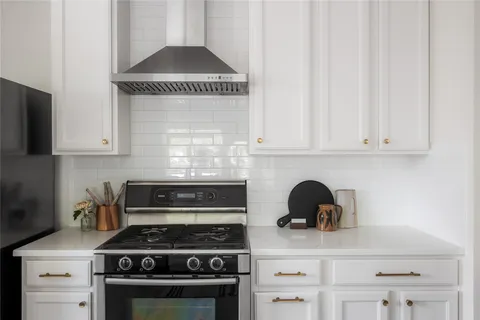 a kitchen with a stove and white cabinets