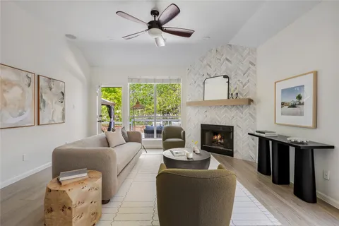 a living room with furniture a large window and a fireplace