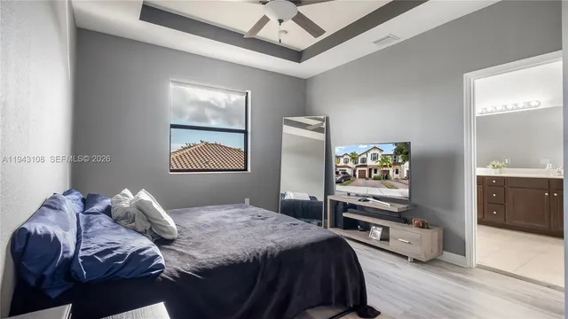 a bedroom with a bed and a dresser with wooden floor