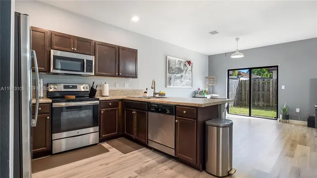 a kitchen with stainless steel appliances granite countertop a stove a sink and a refrigerator