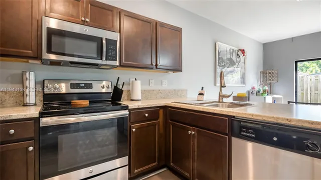 a kitchen with stainless steel appliances granite countertop wooden cabinets and a stove top oven