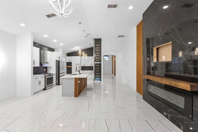 a large kitchen with a stove a refrigerator a sink dishwasher with a dining table and chairs