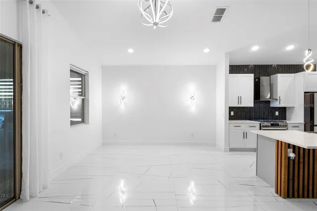 a kitchen with stainless steel appliances kitchen island granite countertop a refrigerator and a stove top oven