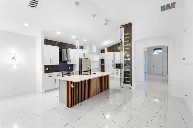 a large kitchen with stainless steel appliances a stove and a refrigerator