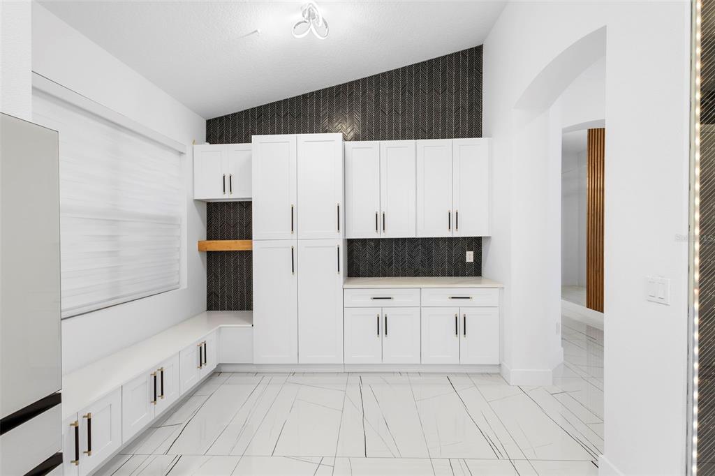 2342 Kaley Ridge Road Clermont, FL 34715 - Photo 29 of 54 a kitchen with white cabinets a refrigerator and a stove