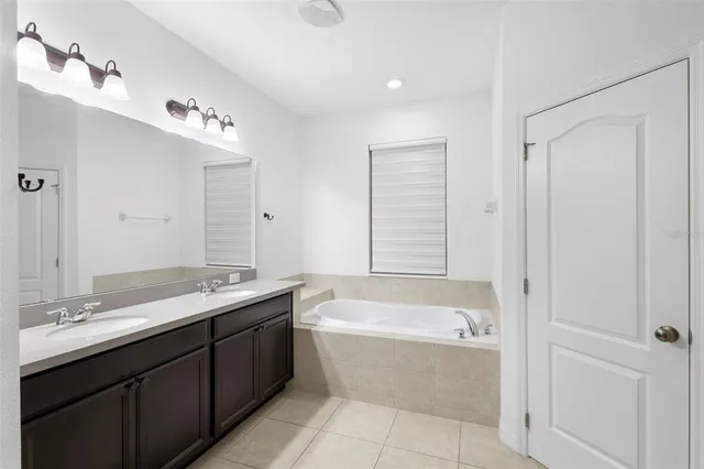 a large white kitchen with a refrigerator a stove top oven and a sink
