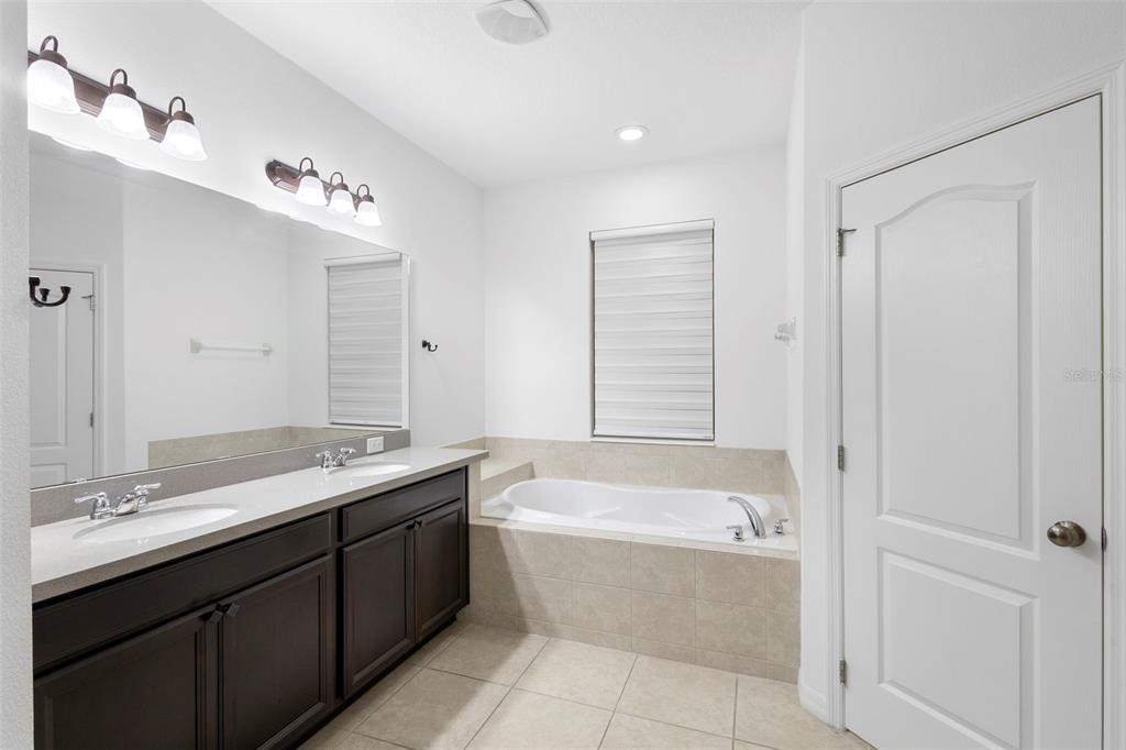 2342 Kaley Ridge Road Clermont, FL 34715 - Photo 38 of 54 a bathroom with a bathtub sink double vanity and mirror
