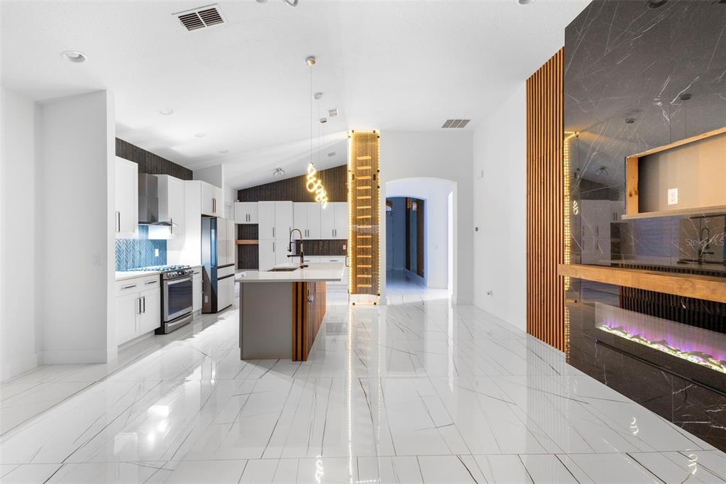 2342 Kaley Ridge Road Clermont, FL 34715 - Photo 42 of 54 a large white kitchen with a refrigerator a stove top oven and a sink