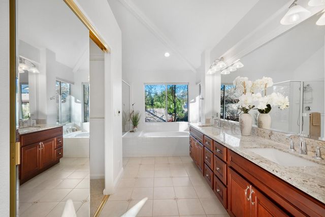 a large bathroom with a granite countertop double vanity sink a bathtub and shower